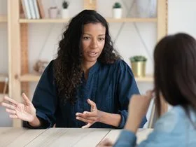 women speaking to another woman